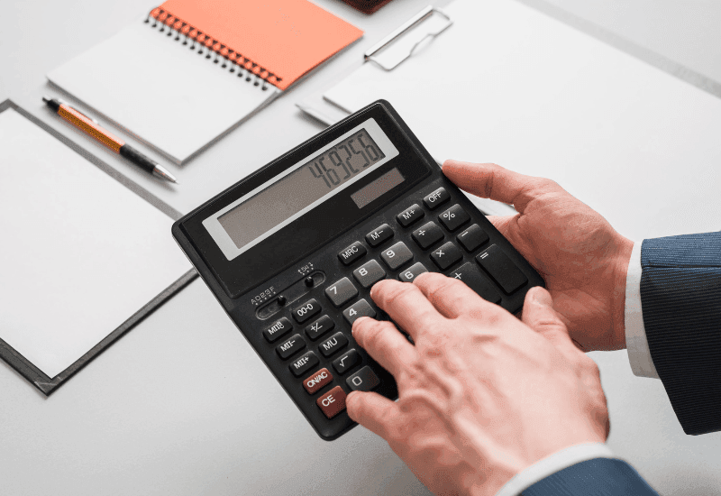 Person using a calculator to estimate mortgage affordability and home financing options in Portugal.